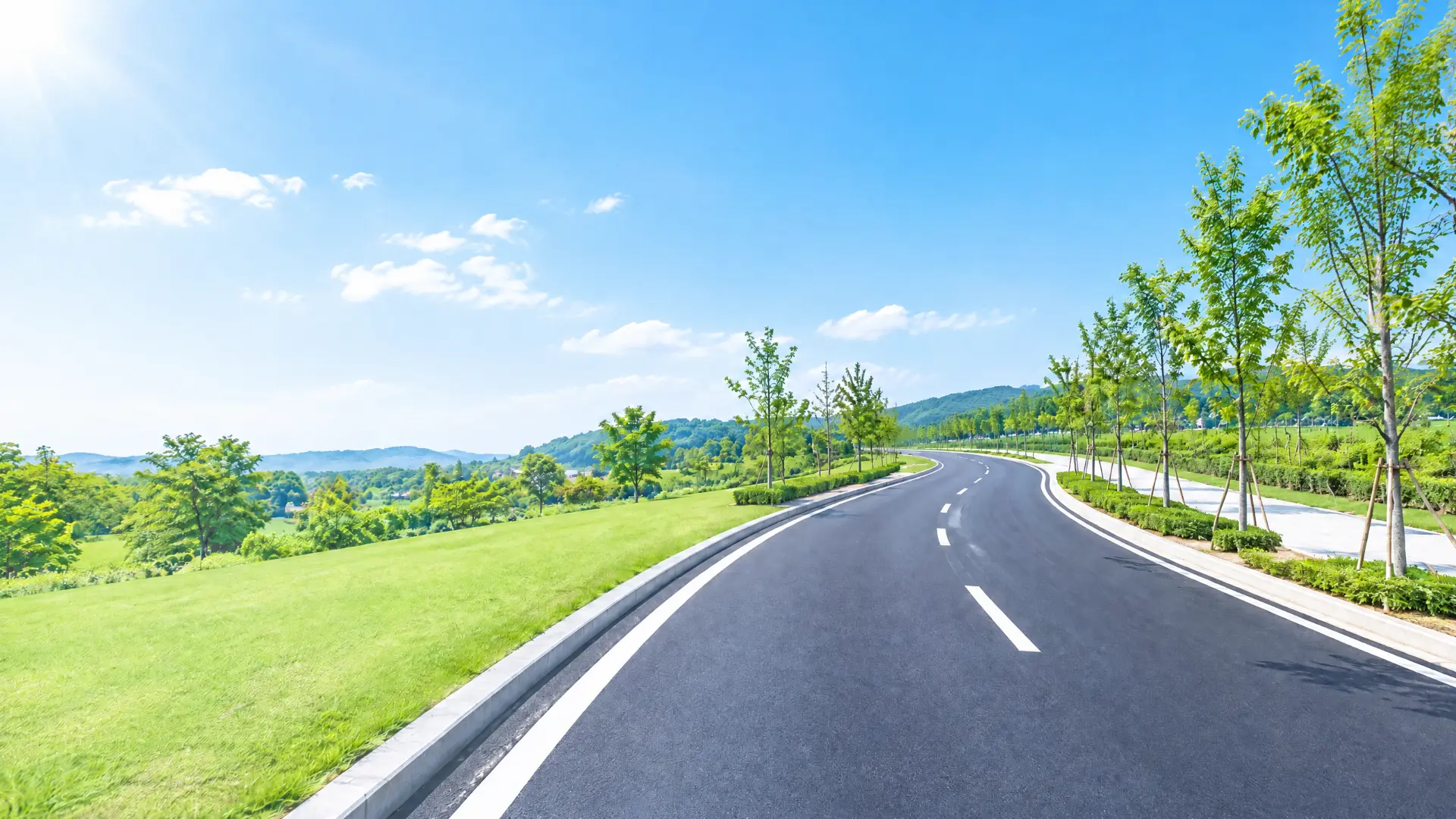 青空と緑に囲まれた舗装道路